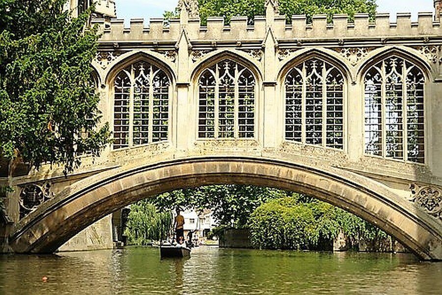 cambridge punting on the river cam under a gothic bridge