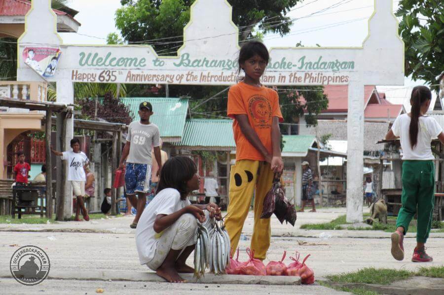 A girl selling fresh fish in the streets of Simunul Island