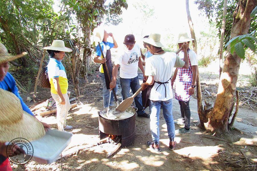 community work stirring the dudol mixture over a fire